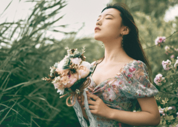 woman in floral dress holding a bundle of flowers
