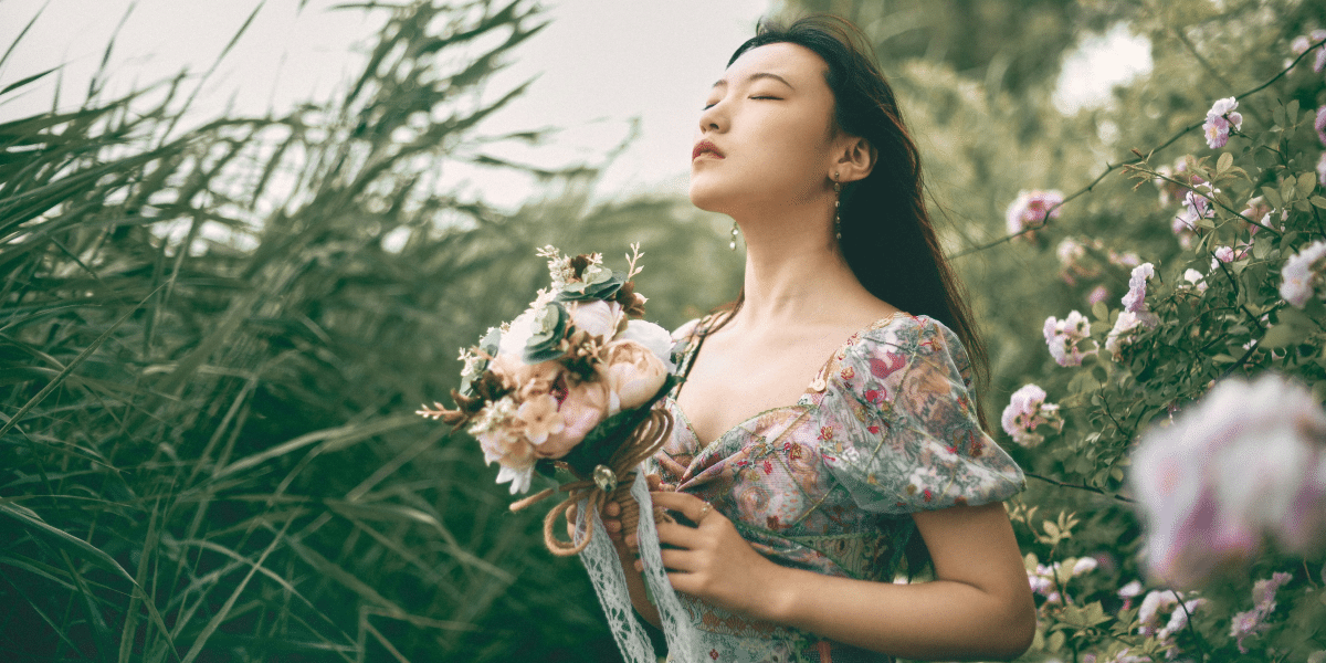 woman in floral dress holding a bundle of flowers